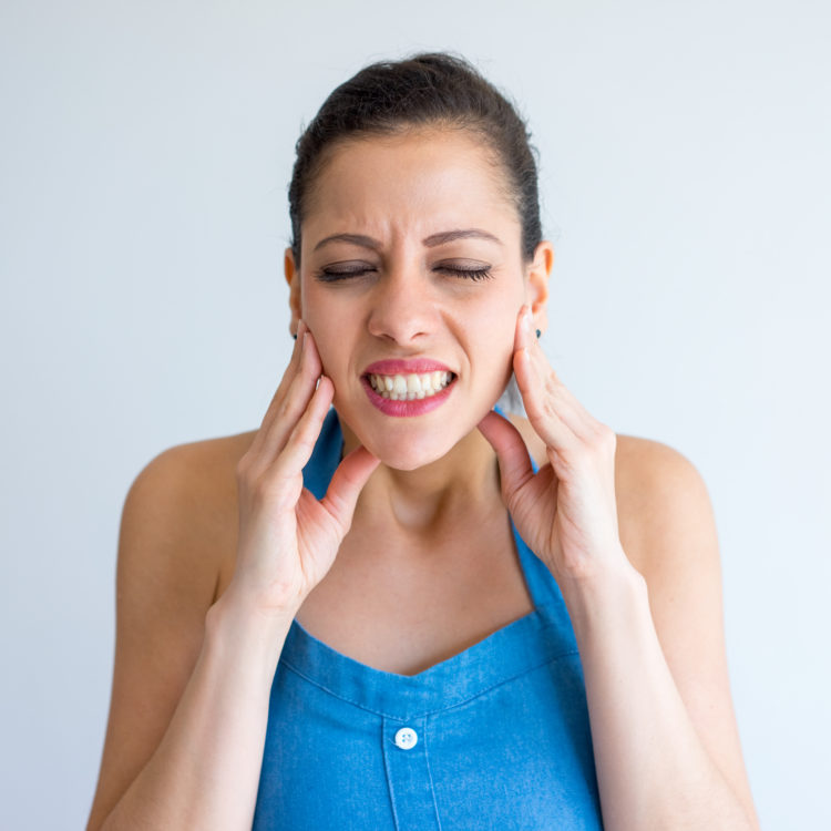 Woman suffering from jaw pain