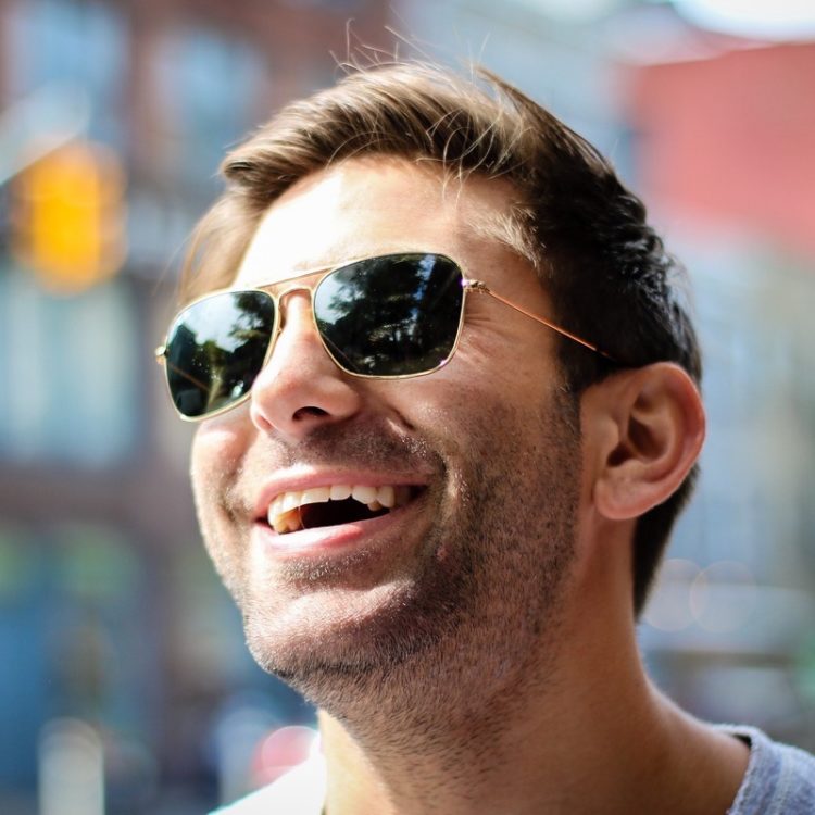 Smiling man with a pair of sunglasses on